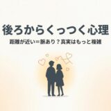 「後ろからくっつく心理」をテーマに、男女が寄り添うシルエットとハートマークが描かれた画像。