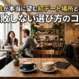 カフェで笑顔の男女が初デート中。手前にはラテアートのコーヒーが2杯。