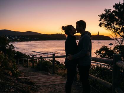 唇を寄せ合うカップルのシルエット、夕暮れの柔らかな光