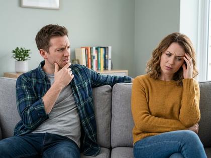 少し距離を置いて座る男女、戸惑った表情