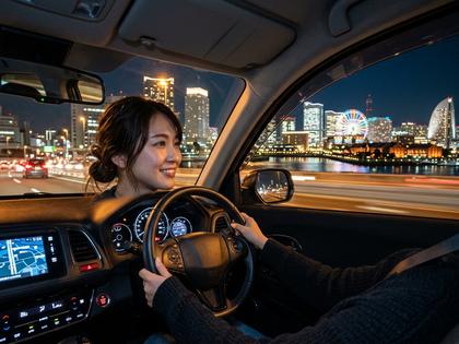 横浜の夜景を眺めながらドライブする女性のイメージ