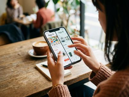 スマホでアプリを比較する女性の手元