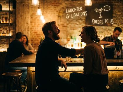 バーで談笑するカップルのシルエット