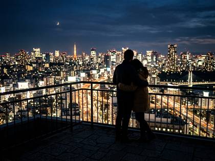 夜景と東京タワーを背景に寄り添うカップル。