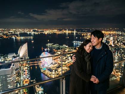 夜景を背景に笑顔で寄り添うカップル。