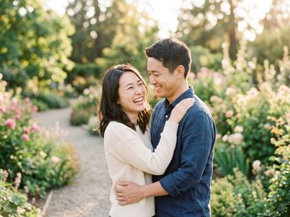 満面の笑顔で抱き合うアジア人カップル。自然光が美しい公園で。