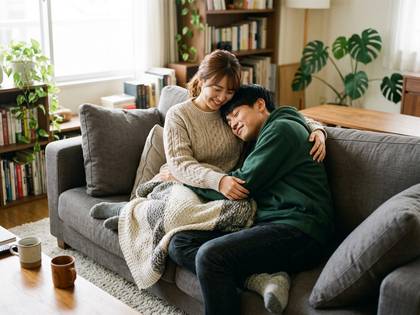 リビングのソファで寄り添い、くつろぐカップル。