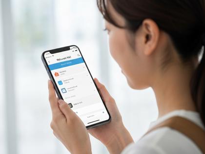 スマホでワクワクメールのプロフィール画面を見ている女性