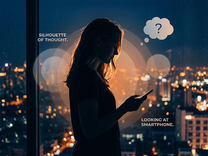 スマホを片手に考え込む女性のシルエット
