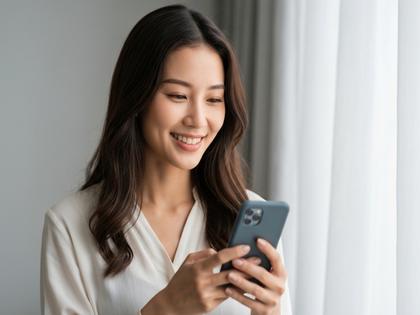 笑顔でスマホを見ている20代女性のポートレート