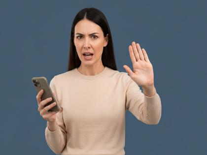 スマホを片手にきっぱり断る意思を見せる女性