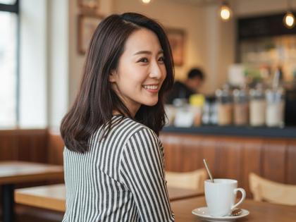 カフェで微笑む20代女性の後ろ姿