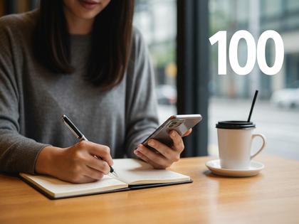 カフェでスマホ片手にメモをとる女性