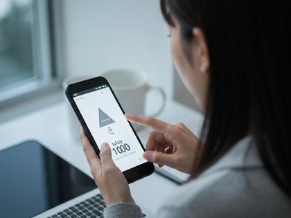 スマホで安全マークを確認している女性のイメージ写真