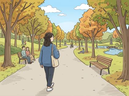 紅葉した木々が美しい秋の公園。道を歩く女性と、ベンチで休む人々。(37文字)