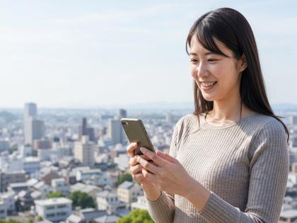 笑顔でスマホを見る女性と佐賀の街並みのイメージ