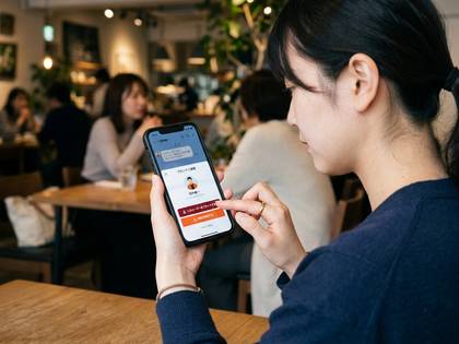 カフェでスマートフォンを操作する女性。
