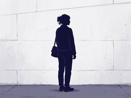 壁の前に立つ、バッグを肩にかけた人物のシルエット。
