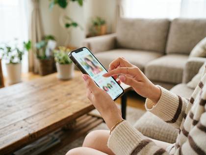 スマートフォンでアプリを操作し、画面に表示された写真を閲覧する手元。