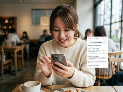 カフェでスマートフォンを操作する笑顔の日本人女性。
