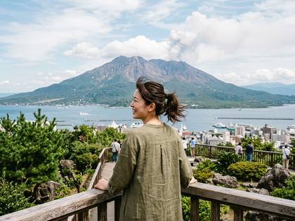 桜島を背景に微笑む女性の後ろ姿