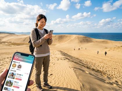 鳥取砂丘を背景にスマホを見ている女性のイメージ