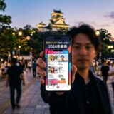 高知城を背景に、マッチングアプリ「Kochi Meet」の画面を見せる男性。