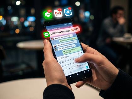 スマートフォンでLINEに素早く返信している女性の手元のイメージ