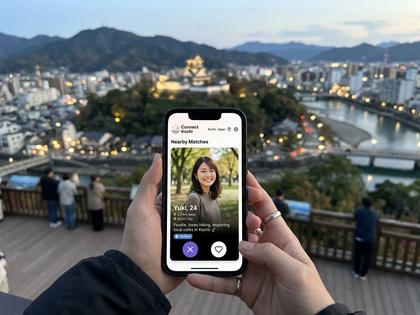 高知の街並みとスマホでマッチングアプリを開く女性のイメージ