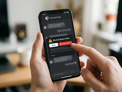 スマートフォンでブロック・通報ボタンをタップしている女性の手元のクローズアップ、800×600